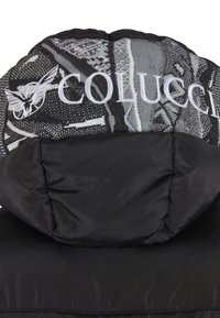 Čierna puff jacket s kapucňou a vyšitým motýľom a čiastočným logom "Colucci" v bielej farbe na monochromatickej vzorovanej látke.