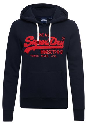 Sweat à capuche bleu marine avec cordons blancs, logo rouge "SuperDry" et caractères asiatiques sur la poitrine, la poche avant et les manches longues.