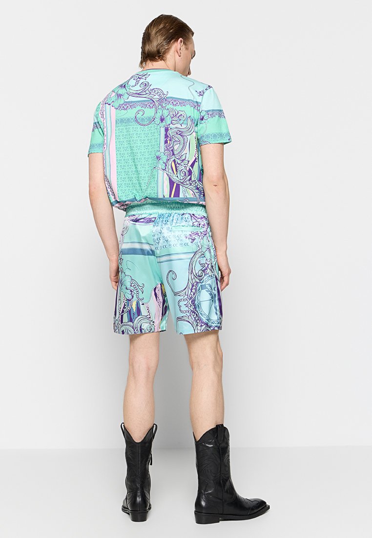 Kurzärmliges, mintgrünes Hemd und passende Shorts mit aufwendigen lila und blauen Mustern. Aus glattem, leichtem Stoff gefertigt.