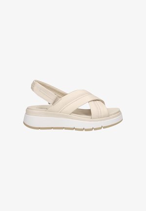 Beige leather slingback sandals with crisscross straps, cushioned footbed, and a white platform sole featuring grooves for traction.
