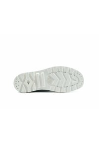 Podeszwa buta wykonana z teksturowanego białego materiału gumowego, z zygzakowatym wzorem i małymi okrągłymi wypustkami zapewniającymi przyczepność i stabilność.