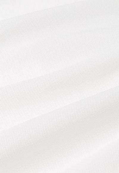 Tissu blanc texturé avec un motif de côtes subtil, présentant des vagues douces et lisses, sans matériel ni accents visibles.