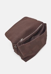 Ruskea laukku, jossa on teksturoitu muotoilu, vetoketjullinen sulkeminen ja sisätasku. Valmistettu kestävästä materiaalista, jossa on pehmeä pinta.