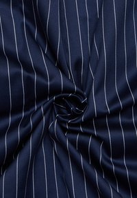 Tessuto blu marino con sottili righe bianche, che mostra una texture liscia e una leggera lucentezza, attorcigliato in una forma a spirale. Ideale per abbigliamento formale.