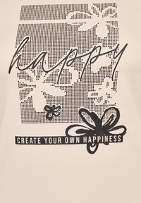 Stoff in crema mit schwarzer Schrift "happy", das ein gepunktetes Muster und florale Designs zeigt, zusammen mit dem Satz "CREATE YOUR OWN HAPPINESS."