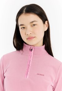 Rosa Fleece-Pullover mit hohem Kragen, Halb-Reißverschluss-Design, mit kontrastierendem Reißverschluss und Logostickerei auf der Brust. Weicher Stoff.