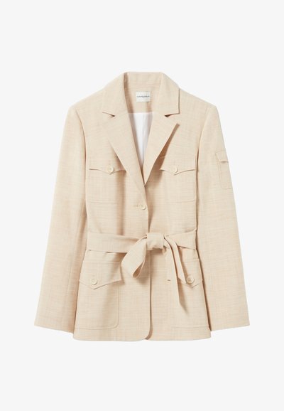 Veste ajustée beige clair avec de grandes poches frontales, une ceinture à la taille et un col à revers. Tissu texturé avec un motif discret.