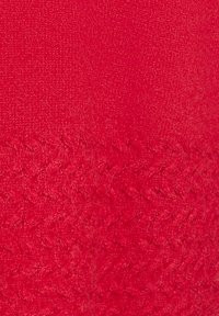 Roter Strickstoff mit glatter Textur, ausgestattet mit einem gemusterten Rand in einem engen Zopfmuster.