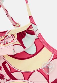 Top bikini colorato con motivi rosa e gialli, bordo arricciato sul colletto, spalline regolabili e dettaglio del logo a forma di cuore.