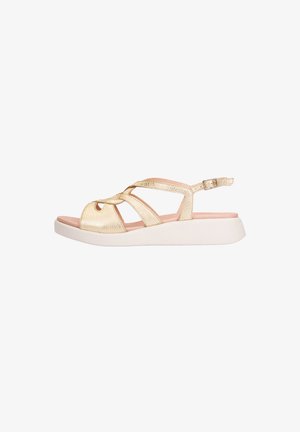 Gold open-toe sandal with crisscross straps, adjustable ankle buckle, cushioned pink insole, and thick white sole.