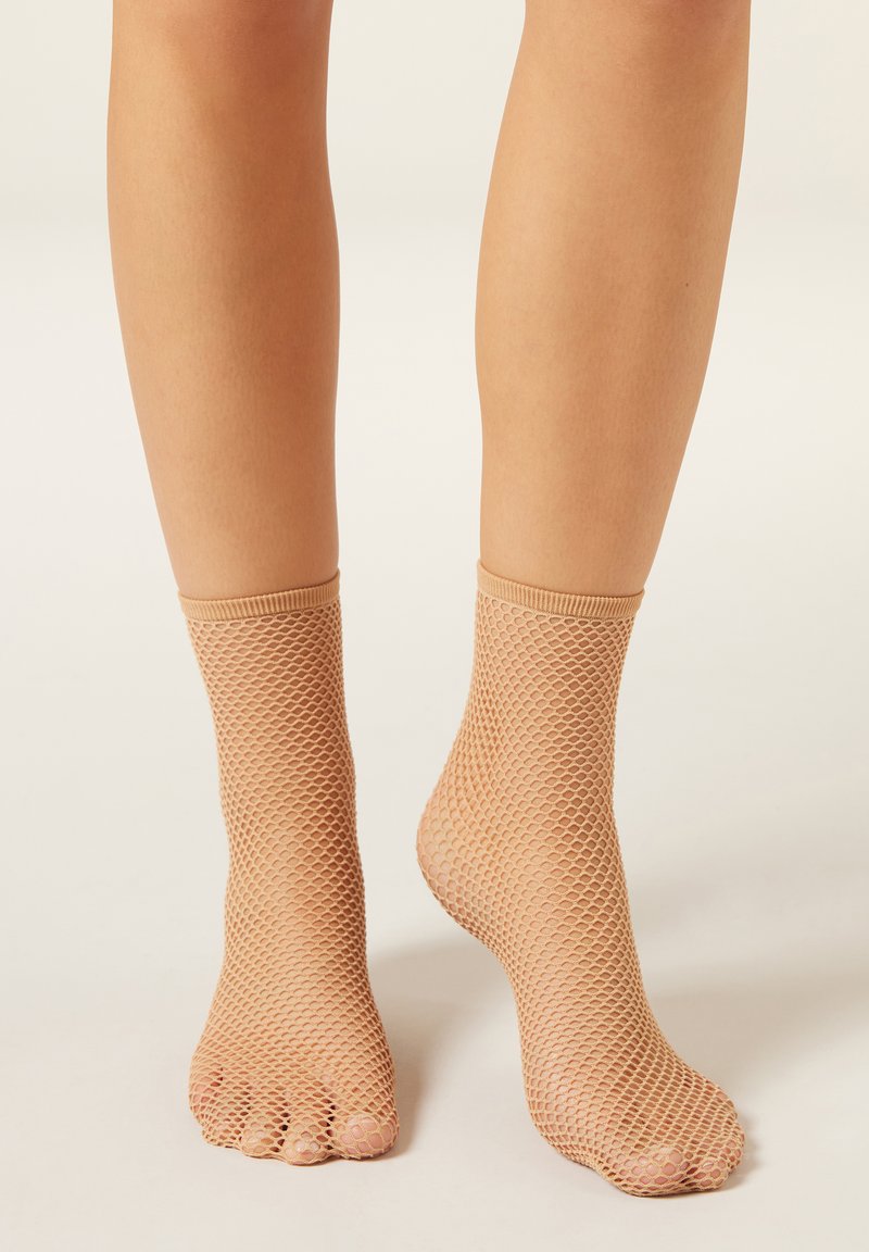 Tělové kotníkové ponožky ze síťoviny s otevřenou špičkou, s texturovaným vzorem a elastickými lemy pro pevné držení.
