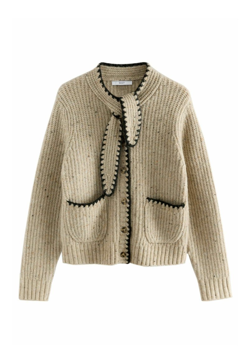 Beige Strickjacke mit strukturiertem Muster, schwarzem Saum und zwei vorderen Taschen. Verfügt über eine Krawatte am Kragen und einen Knopfverschluss.