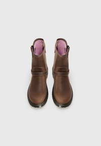 Brown leather ankle boots with pink lining, featuring side zippers, a front strap, and a black sole with yellow stitching.