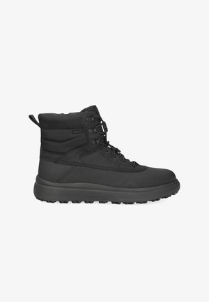 Czarne buty trekkingowe o wysokiej cholewce, wykonane z trwałego materiału, z sznurowadłami, teksturowanym wierzchem i solidną, gumową podeszwą.