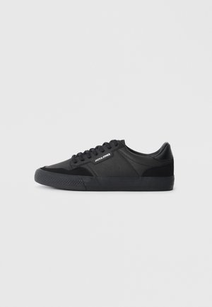 Baskets noires en mélange cuir et daim, avec des lacets ronds, une semelle en caoutchouc texturée et un logo de marque sur le côté.