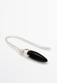 Spilla di sicurezza in argento con un accento in pietra nera allungata e testurizzata, fissata da un filo avvolto, su sfondo bianco.