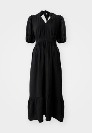 Melnas kleitas, kas izgatavota no teksturētas auduma, ar vidēju garumu, pūkām uz piedurknēm, atslēgas caurumu dekoltē un pakāpenisku apakšmalu. Iezīmē elastīgu jostu.