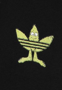 Personaggio verde a forma di stella fuzzy con occhi e sorriso, striato a metà, su uno sfondo nero.