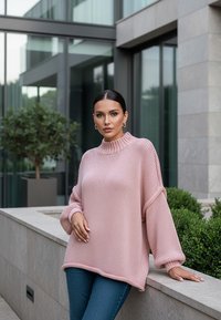 Jasnoróżowy sweter dzianinowy z wysokim kołnierzem, bufiastymi rękawami i teksturowanym materiałem, zestawiony z niebieskimi dżinsami, w nowoczesnej architektonicznej scenerii.