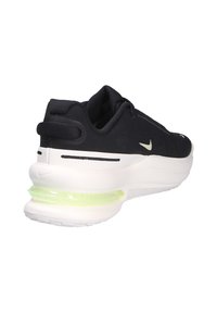 Scarpa sportiva nera con suola bianca ammortizzata e un'unità d'aria verde. Presenta una tomaia testurizzata e dettagli di brand minimi.