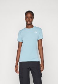 Lichtblauw t-shirt met korte mouwen, gemaakt van zachte stof, met een ronde halslijn en een klein wit logo op de bovenste linkerkant.