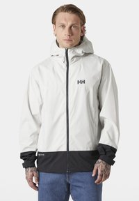 Weiße wasserdichte Jacke mit schwarzem Saum, durchgehendem Reißverschluss und Kordelzugkapuze. Mit einem Logo auf der Brust und gerippten Bündchen.