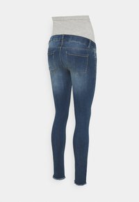Tmavě modré skinny džíny s šedým elastickým pasem. Mezi další vlastnosti patří dvě zadní kapsy a mírně třepený lem. Vyrobeno z denimu.