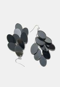 Czarno-srebrne wiszące kolczyki składające się z kilku nakładających się na siebie owalnych kształtów o gładkiej fakturze, zawieszone na prostym haczyku.