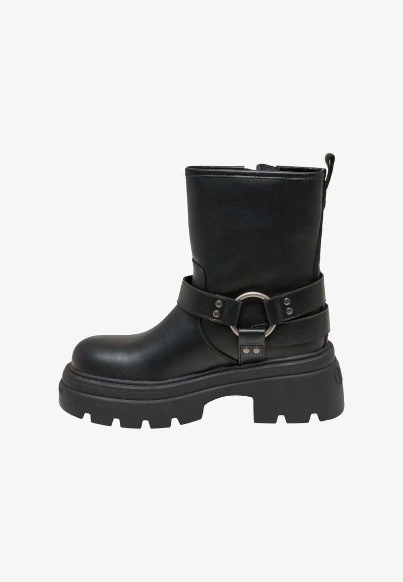 Botín de cuero negro hasta el tobillo con suela gruesa, que presenta una correa con un acento de anillo plateado. Textura suave, punta redondeada y tirador en la parte posterior.