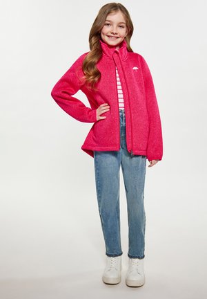 Jachetă din fleece fucsia cu guler înalt și fermoar complet, asortată cu o cămașă cu dungi și blugi de culoare albastru deschis; teniși albi completează ținuta.
