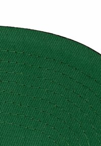 Tejido verde tejido con superficie texturizada y líneas cosidas. Forma circular con un borde suave, que muestra una costura ordenada y consistente.