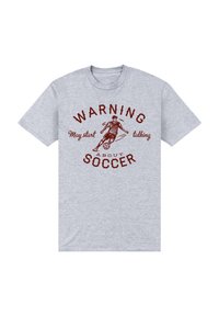Camiseta de algodón gris con un diseño gráfico rojo que incluye el texto "ADVERTENCIA: Puede empezar a hablar sobre FÚTBOL" y una ilustración de un jugador de fútbol.