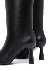 Zwarte laarzen tot de knie van soepel leer met een glanzende afwerking, met een slanke Silhouet en een hoge hak.