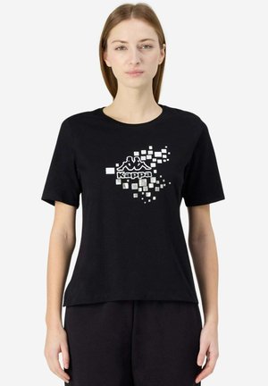 T-shirt nera in cotone, con logo Kappa bianco stampato e design pixelato sul davanti. Maniche corte e scollatura a girocollo.