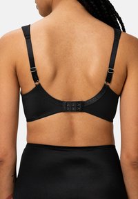 Mustat rintaliivit, joissa on säädettävät hihnat, pehmeä kangas ja hakashäntä-suljenta takana. Ominaisuuksiin kuuluu sileä pinta ja minimalistinen muotoilu.