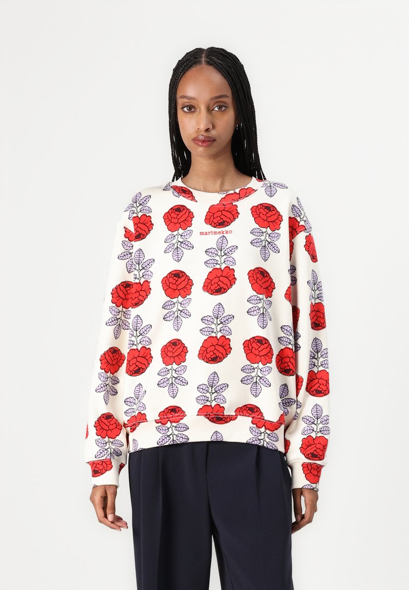 Sweatshirt features a cream base with a bold red and purple floral pattern. Made from soft fabric with a relaxed fit and ribbed cuffs.