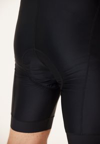 Svarta cykelbyxor i ett stretchigt material. Har en texturerad yta, tajt passform och elastisk midja med en vadderad insats.