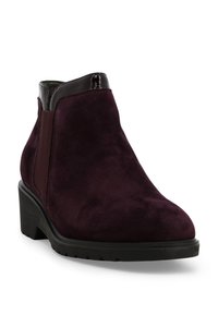 Stivaletto alla caviglia in camoscio bordeaux con punta arrotondata, dettaglio lucido al collo, pannello elastico laterale e suola in gomma nera testurizzata.