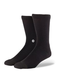 Calcetines negros de tela acanalada, con puntera y talón reforzados, y un pequeño logo blanco en el lateral. Longitud hasta la mitad de la pantorrilla.