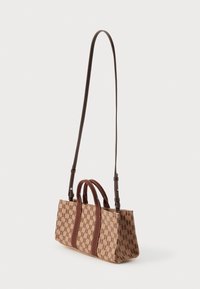Hnědá kabelka s vzorem, se dvěma rukojeťmi a dlouhým nastavitelným popruhem. Vyrobena z odolného materiálu s kontrastními hnědými akcenty.