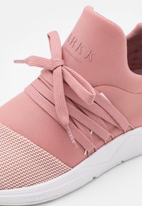 Rosa Sport Schuh mit einer strukturierten Mesh-Zehenspitze, elastischen Schnürsenkeln und einem gepolsterten Kragen. Verfügt über eine weiße Gummisohle und ein eingeprägtes Logo.