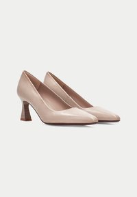Le scarpe col tacco alto in pelle beige presentano un design a punta, un tacco a blocco testurizzato e una fodera interna liscia.