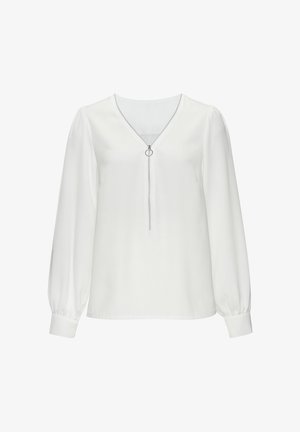 Valkoinen pitkähihaisia paita, jossa on V-mallinen kaula-aukko ja edessä vetoketju, jossa on pyöreä vetoketjun veto. Valmistettu sileästä kankaasta, jossa on hieman puffattuja hihoja.