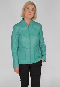 Teal Lederjacke mit Kragen, Frontreißverschluss und zwei unteren Taschen. Glatte Textur, taillierte Passform und strukturiertes Design.