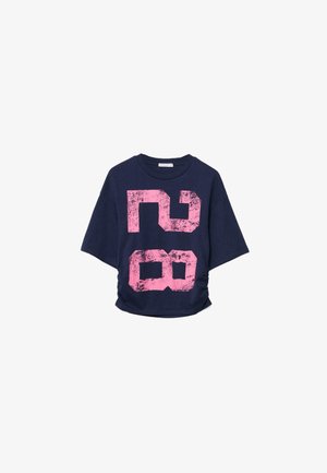 Tmavomodrá košeľa s krátkym rukávom s ružovým, opotrebovaným veľkým číslom "28" vytlačeným na prednej strane, mierne nariasená na jednej strane.