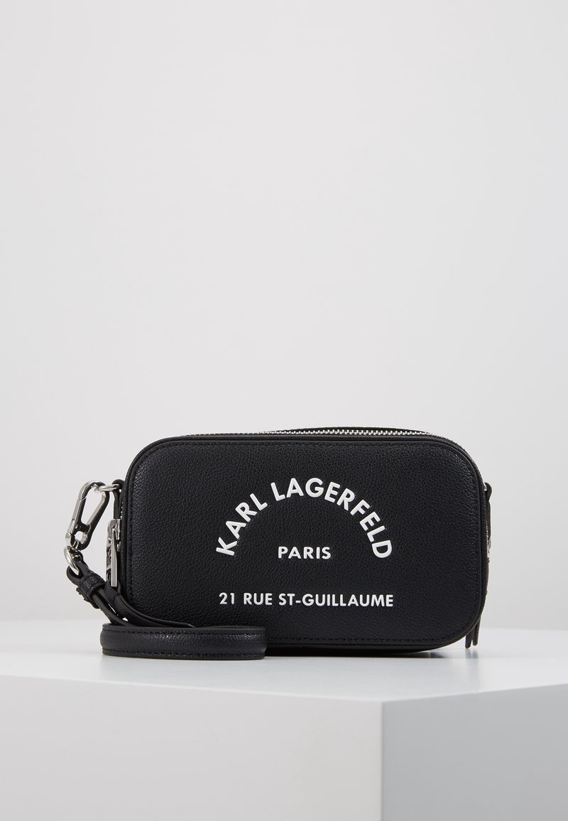 Borsa rettangolare nera in pelle con accessori in argento. La parte anteriore presenta testo bianco impresso e un design strutturato. Include una tracolla removibile.