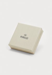 Cutie de cadou pătrată, de culoare bej deschis, cu un model în relief, având numele brandului "PURELEI" imprimat cu text negru intens pe partea din față.