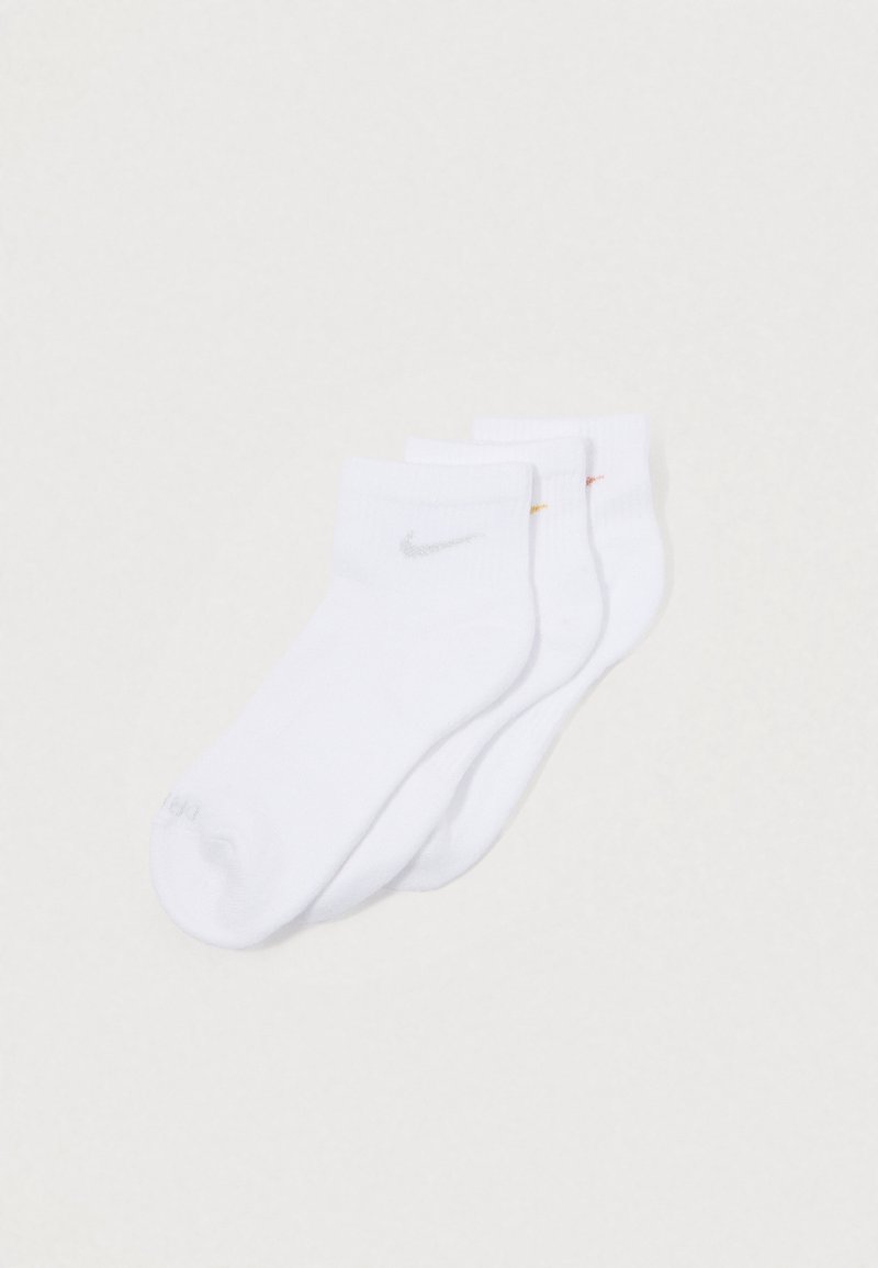 Três pares de meias brancas até ao tornozelo com pequenos logótipos Swoosh da Nike em prata, amarelo e vermelho, sobre um fundo branco.