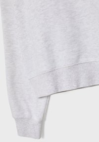 Siv sweatshirt z mehkimi, teksturiranimi materiali z rebrastim manšetnim in spodnjim robom, ki prikazuje preprost, minimalističen estetski pridih.