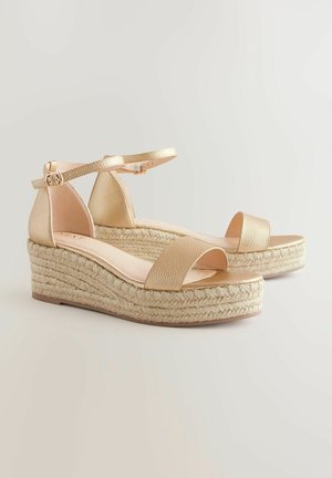 Gouden wig sandaaltjes met een gestructureerde bovenzijde, een enkelbandje en een jute-wikkelde platform, met een soepele teband en een lichtbruine zool.